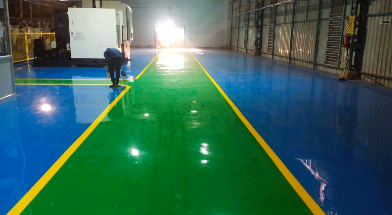 Workers grinding floor surface preparing for epoxy coating